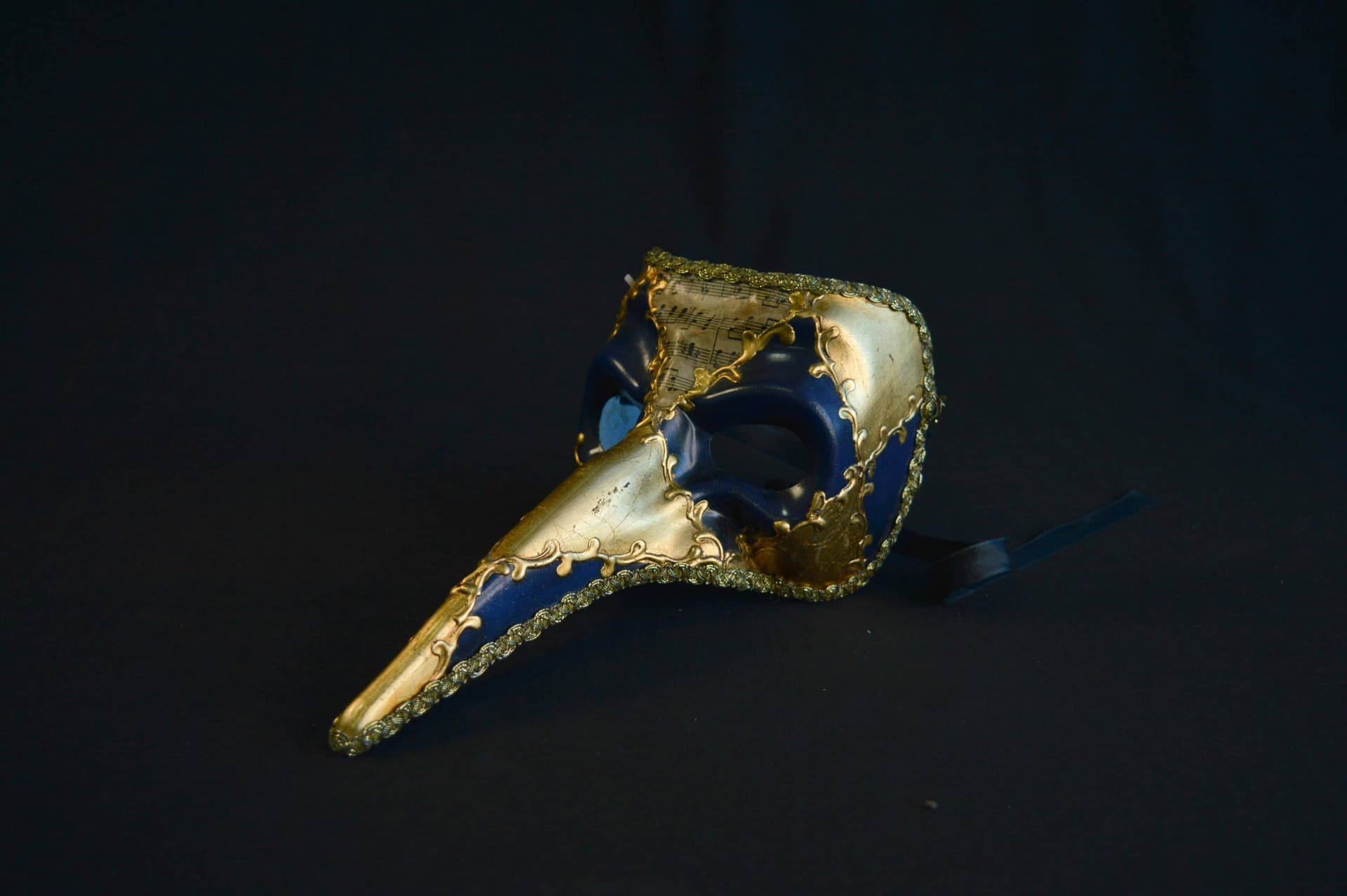 Golden-blue theater mask on a black background