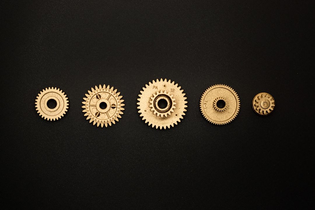 Five metal gears on a black brackground